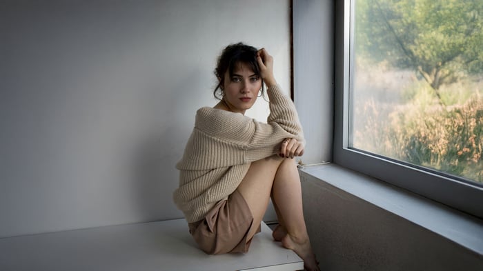 Woman in a cozy sweater sitting by the window