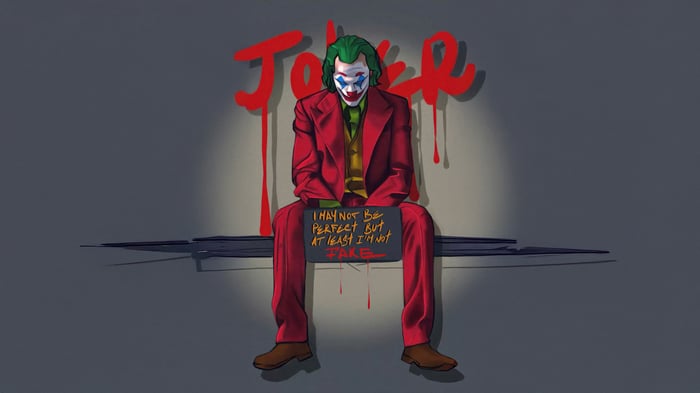 Joker sitting with a sign