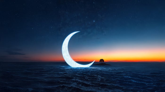 Crescent Moon Over a Wavy Ocean at Sunset