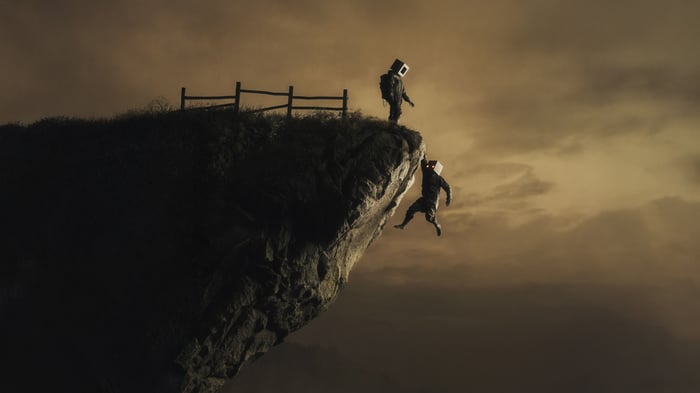 Man on cliff saving friend hanging off edge