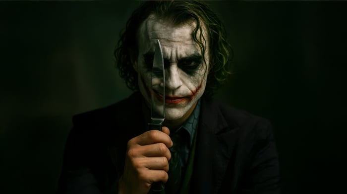 The Joker holds a knife in front of his face
