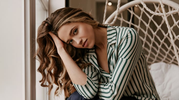 Girl with wavy hair sitting in a hammock chair