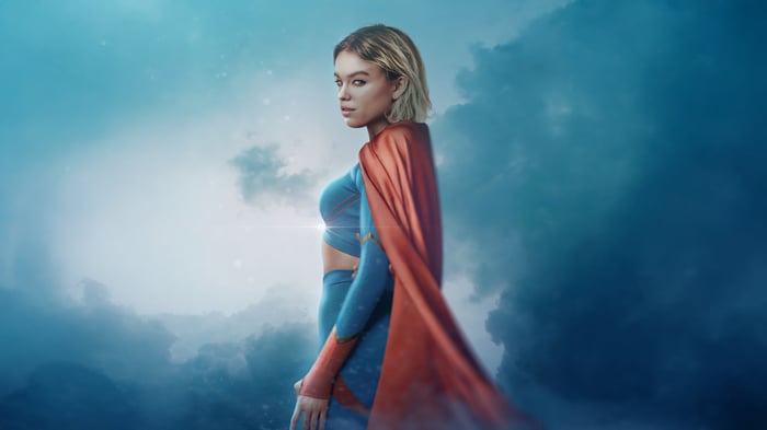 Supergirl in a blue and red costume with a cape