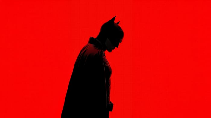 The Batman in silhouette against a red background