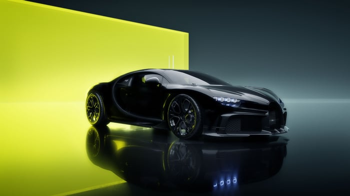 Black Bugatti Chiron on a reflective surface with yellow background