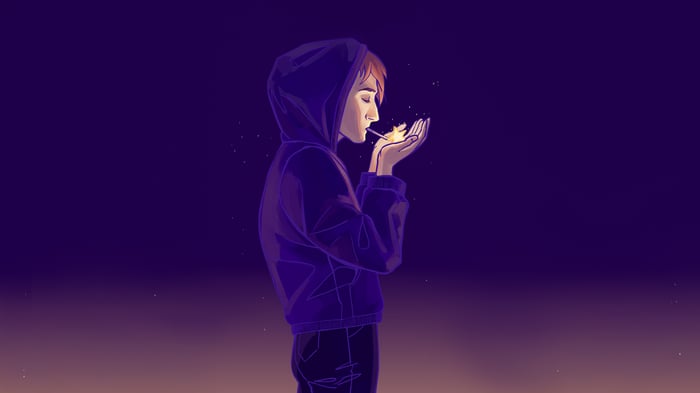 Boy in hoodie lighting a cigarette
