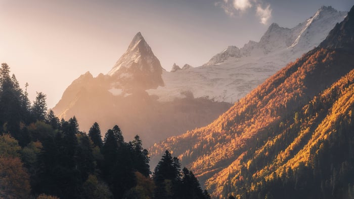 Golden Alpine Peak with Snow Capped Mountains and Autumn Trees