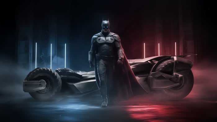Batman and the Batmobile in a dark setting