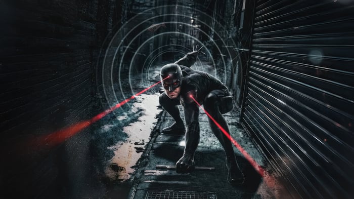 Daredevil in a dark alley with red laser beams