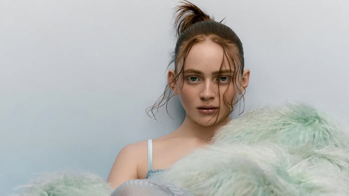 Sadie Sink in a light blue top with a fluffy boa
