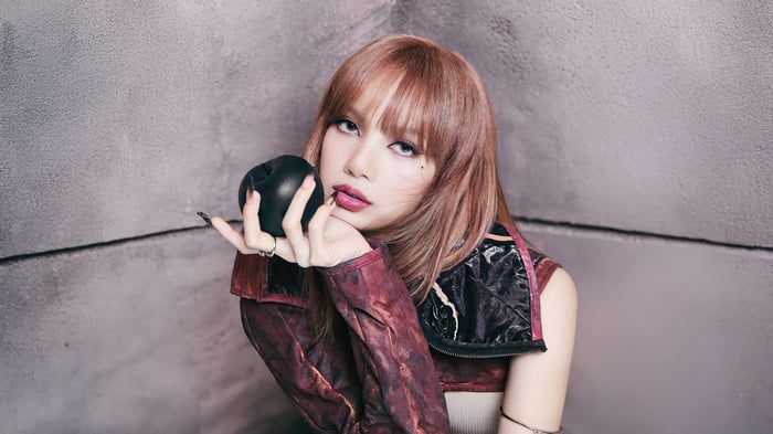 Lisa from BLACKPINK holding a black apple