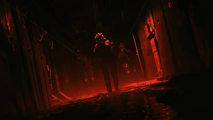 Soldiers in a dark, red-lit corridor with lasers