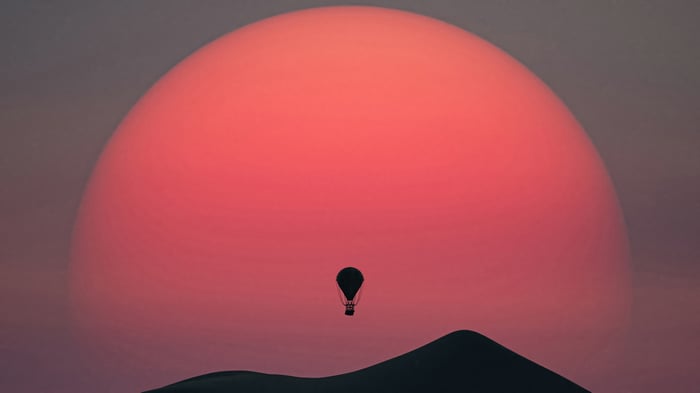 Hot Air Balloon Flying Over Dunes at Sunset 4K