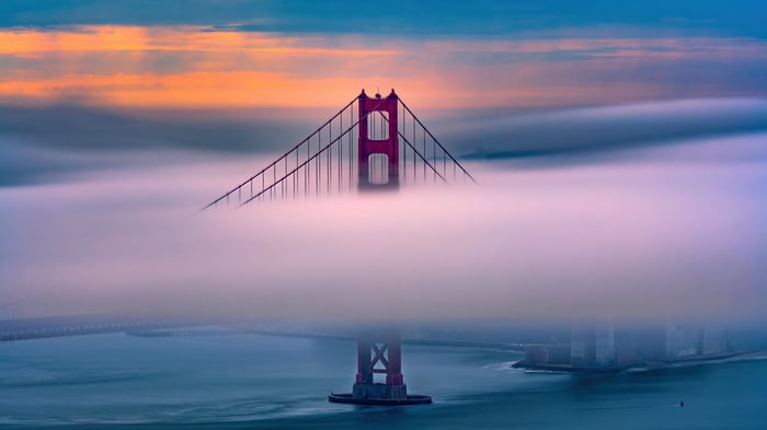 Golden Gate Bridge shrouded in fog at sunrise