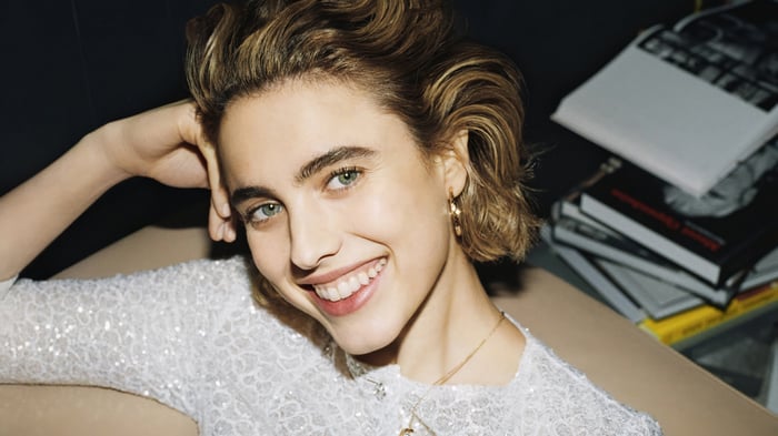 Margaret Qualley smiling in a sequined top