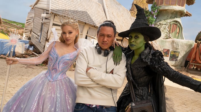 Glinda, Elphaba, and Director Jon M. Chu on the set of Wicked