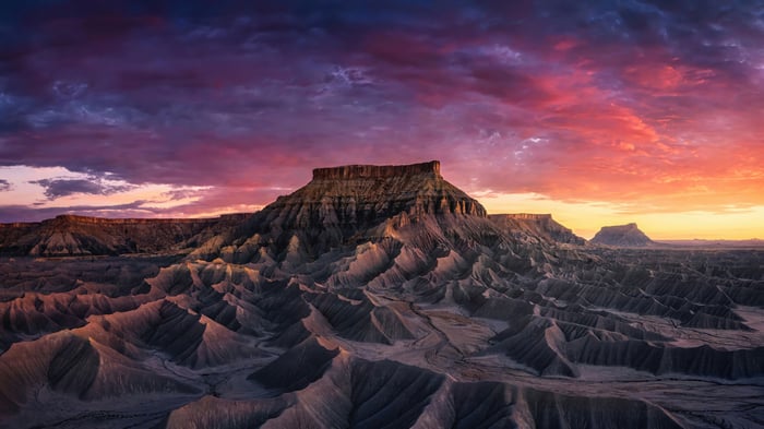 Sandstone formations under a colorful sunset sky