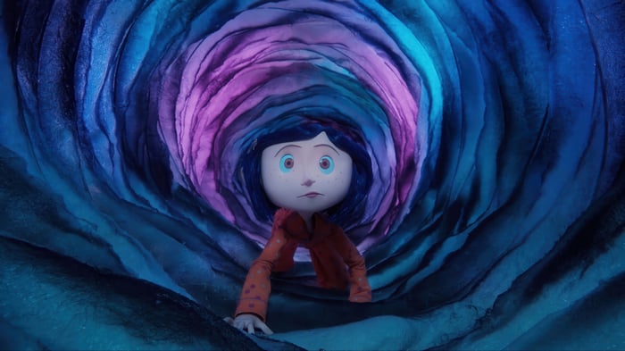 Coraline crawling through a colorful tunnel