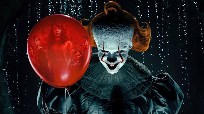 Pennywise the Clown holding a red balloon with children's faces