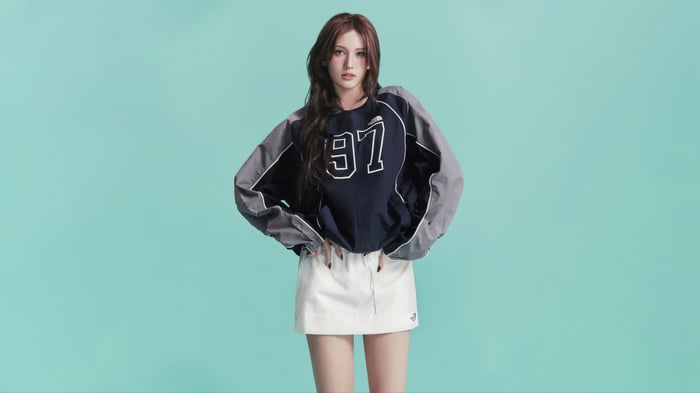 Jeon Somi wearing a navy and gray sweatshirt and white skirt