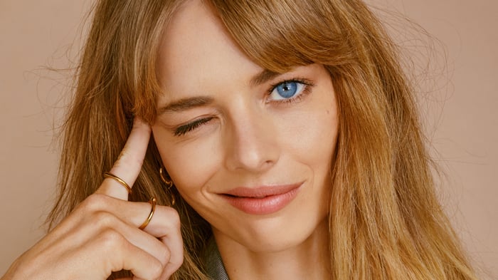 Samara Weaving winks and touches her temple