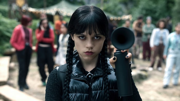 Wednesday Addams holding a black object