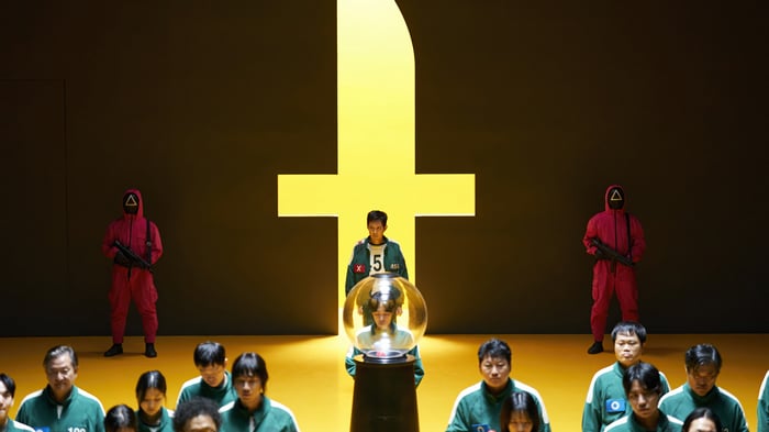Squid Game participants and guards in yellow room