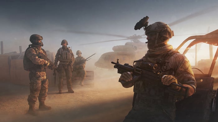 Soldiers in a desert with a helicopter