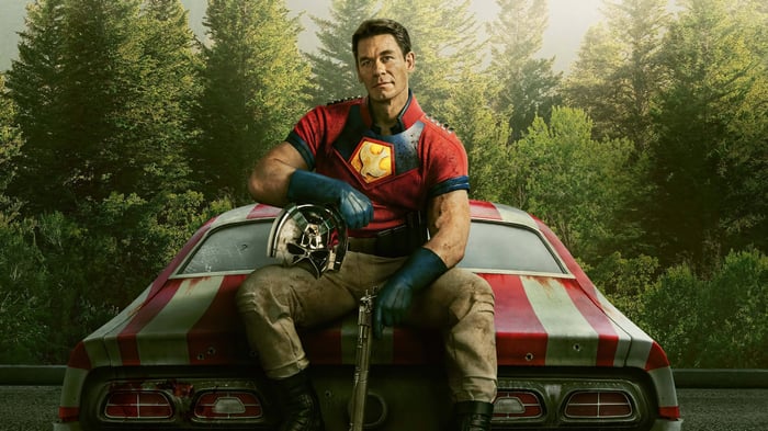John Cena as Peacemaker sitting on a car