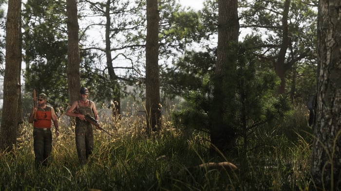 Two men with rifles in a forest