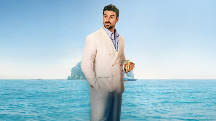 Michele Morrone in a white suit on a yacht