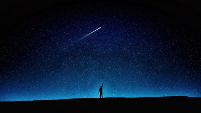 Silhouette reaching for a comet in a starry night sky 4K