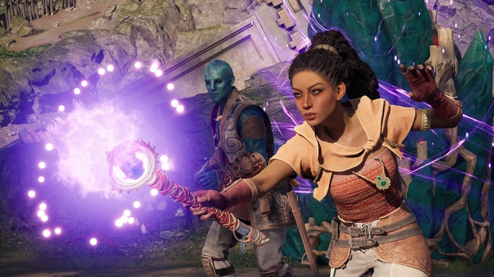Avowed: Woman casting magic with a blue-skinned man behind her