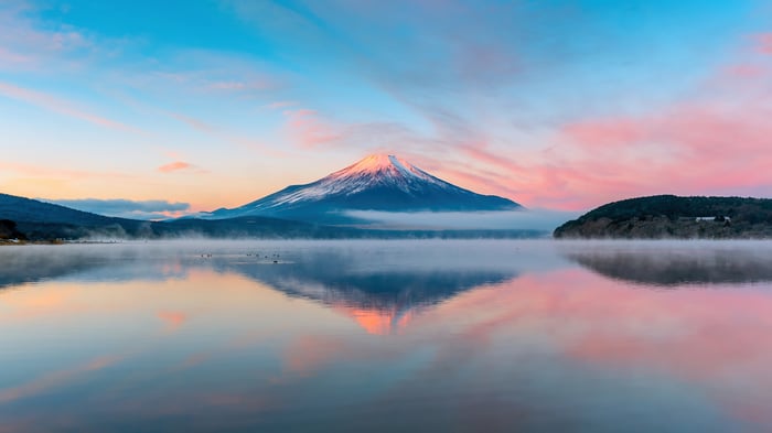 Mount Fuji reflected in a misty lake at sunrise