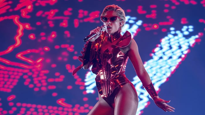Naomi Scott performing in a metallic red outfit