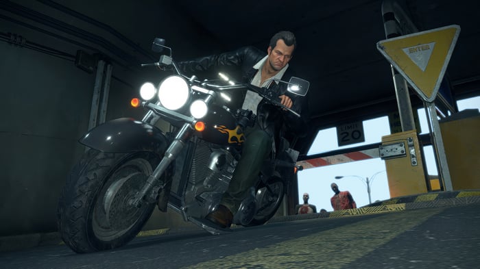 Frank West riding a motorcycle with zombies in the background