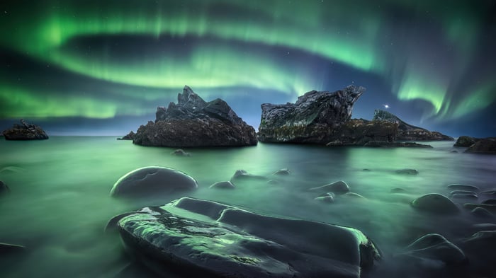 Aurora Borealis over rocky coast 4K