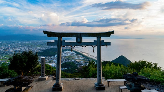 Torii Gate Overlooking a Coastal City and Ocean