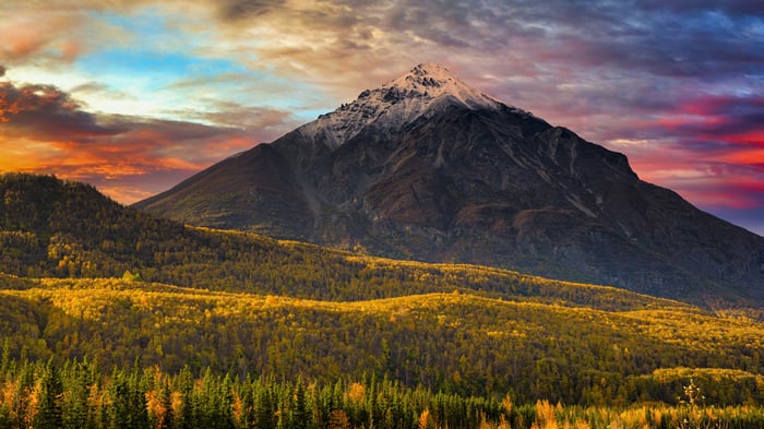 Mountain peak with autumn forest and dramatic sky
