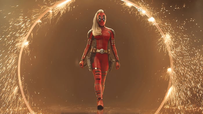 Lady Deadpool walks through a ring of fireworks