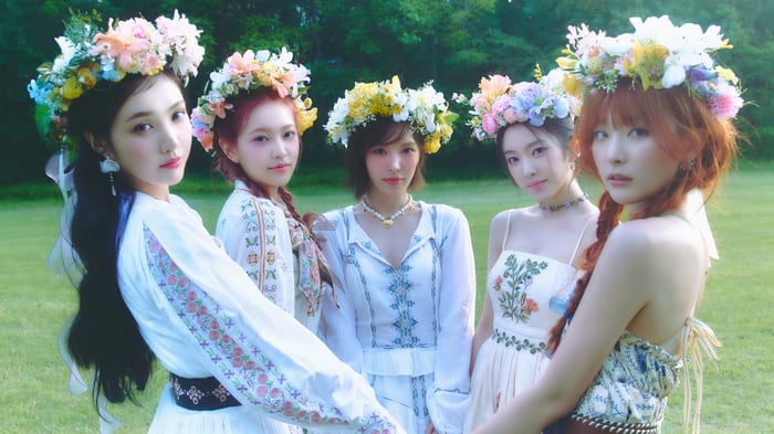 Red Velvet members wearing flower crowns in a field