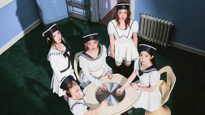 Red Velvet members in sailor outfits around a table