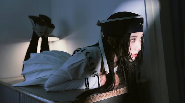 Joy from Red Velvet in a white uniform and hat