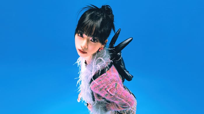 Karina from Aespa in a pink and white fluffy jacket