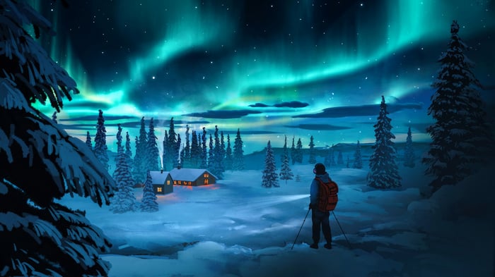 Northern Lights over a snowy landscape with a hiker