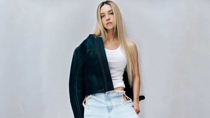 Sydney Sweeney in a white tank top and denim skirt