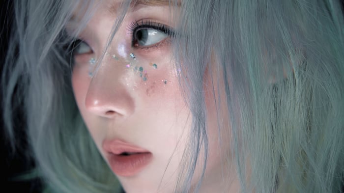 Winter from Aespa with blue hair and glitter makeup