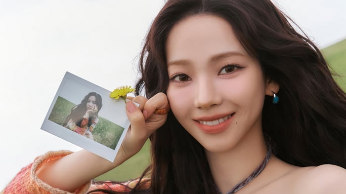 Karina Aespa holding a polaroid photo and a dandelion