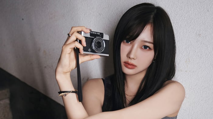 Giselle from Aespa holds an Olympus-Pen camera