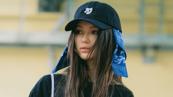 Daielle from NewJeans wearing a black cap and bandana